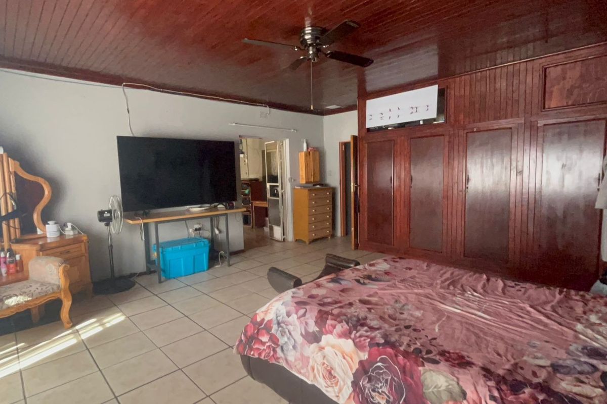 Spacious bedroom featuring extensive built-in timber cabinetry, a matching timber ceiling, and tiled flooring.