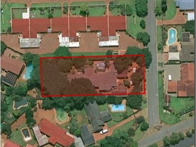 An aerial view of the property highlighting the house footprint, surrounding garden, and roof structure within the residential neighborhood.