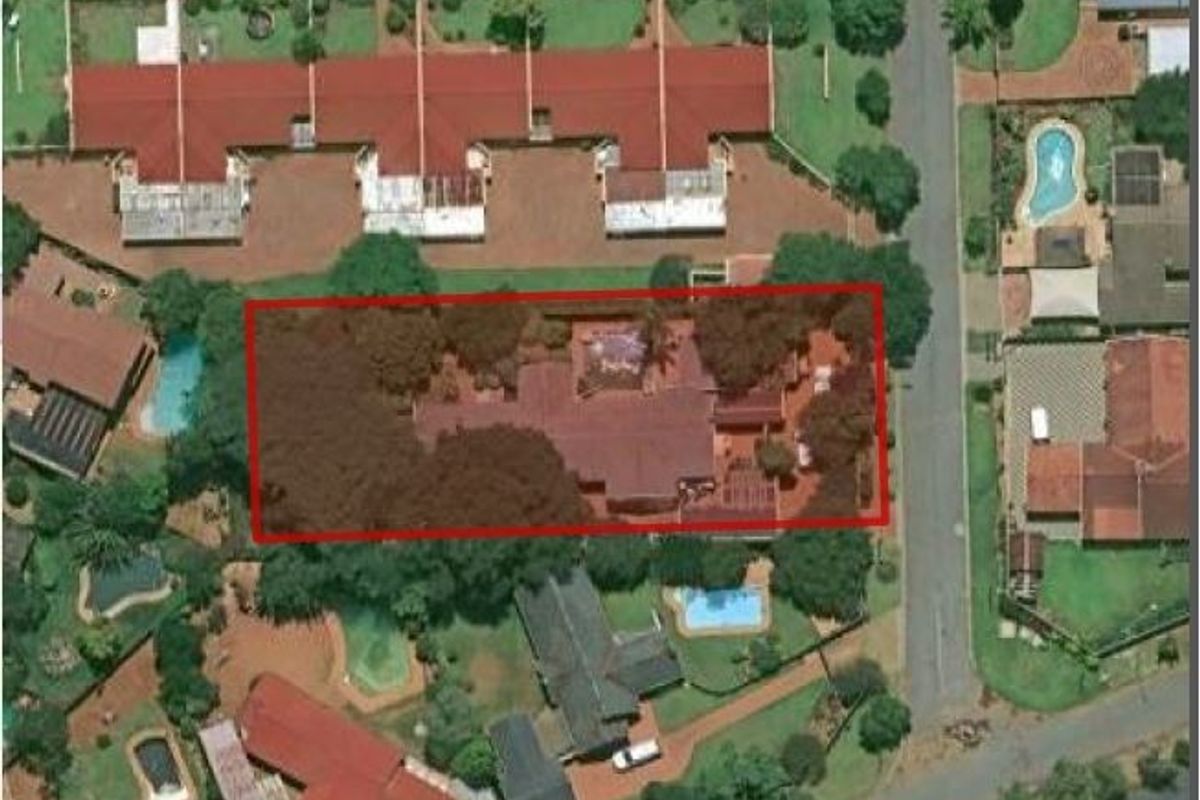 An aerial view of the property highlighting the house footprint, surrounding garden, and roof structure within the residential neighborhood.