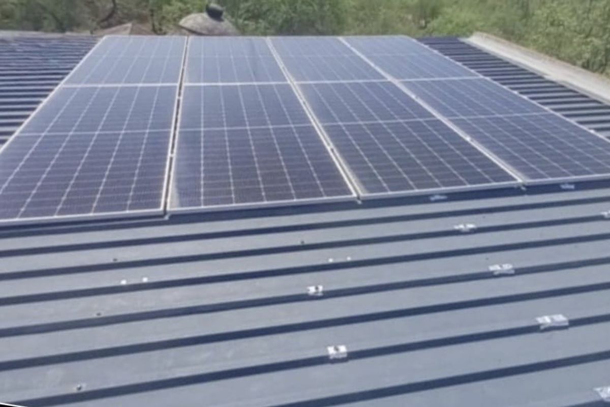 A view of a corrugated metal roof featuring a mounted solar panel array for energy efficiency.