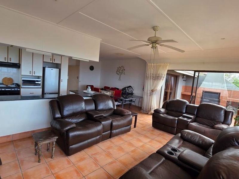 Open-plan living area featuring a kitchen with built-in cabinetry and a seamless flow to the outdoor patio space.