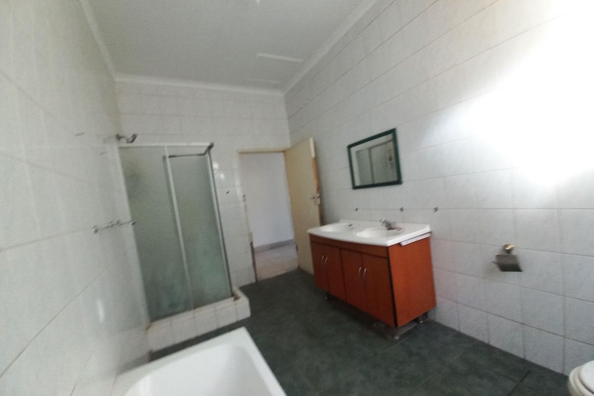 A functional bathroom featuring a shower enclosure, a bathtub, and a vanity cabinet with a basin.
