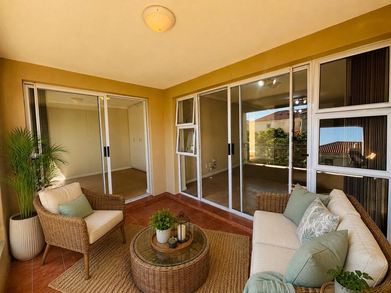 A covered balcony featuring tiled flooring and large sliding glass doors that provide seamless access to the interior living spaces.