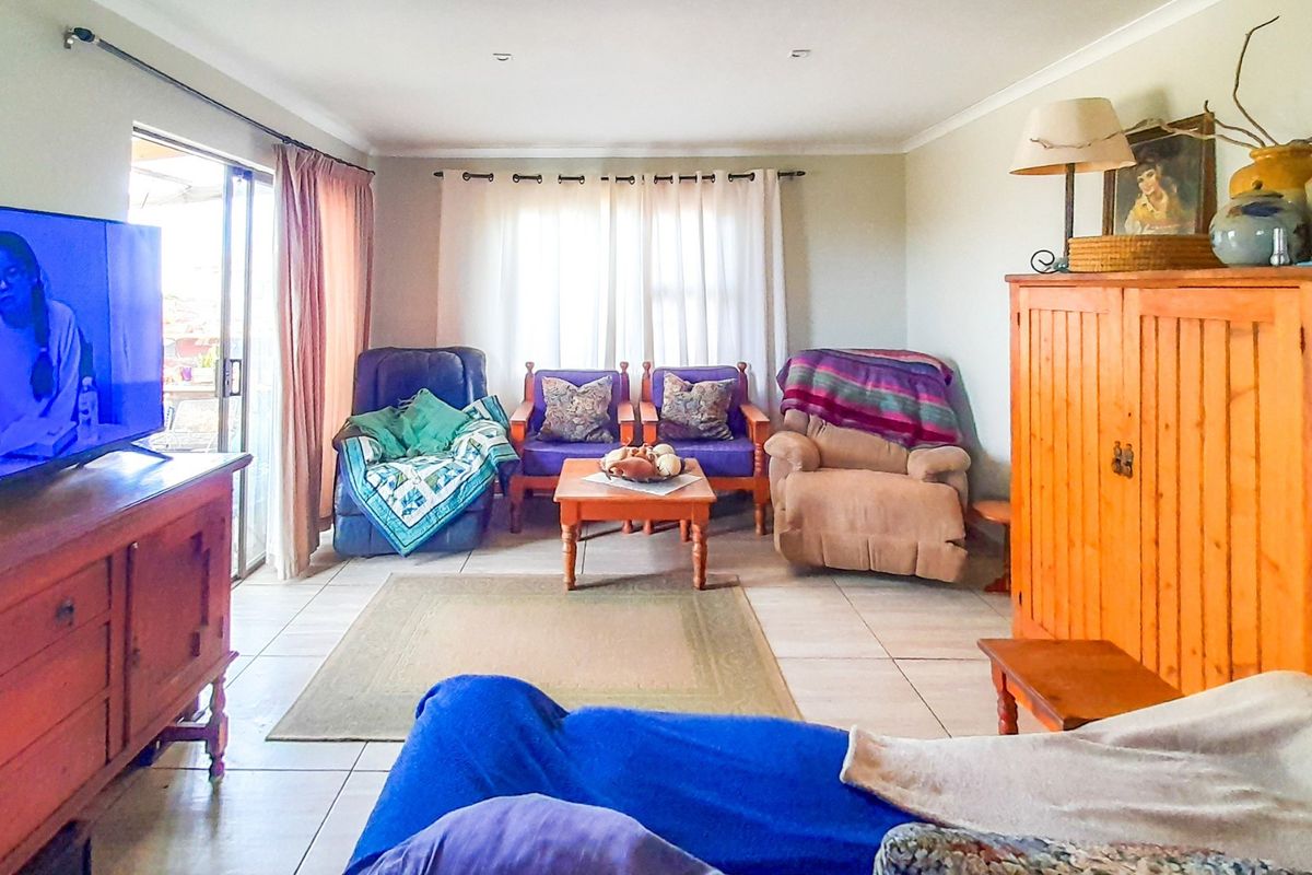 A comfortable living room featuring tiled flooring and sliding glass doors that provide access to the outdoor area.