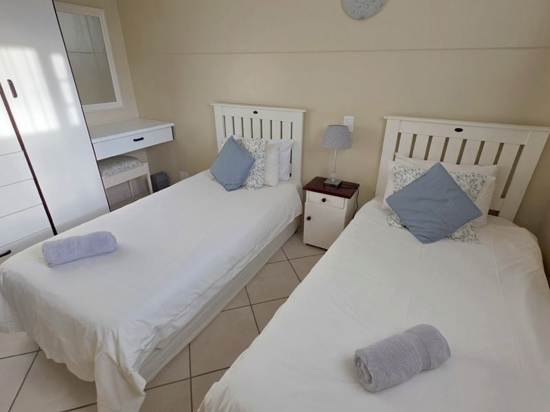 A bedroom featuring tiled flooring and neutral wall finishes, providing a functional and comfortable sleeping space.