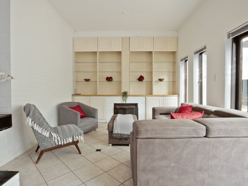 A bright living room featuring built-in cabinetry, a fireplace, and tiled flooring, offering a comfortable and functional space.