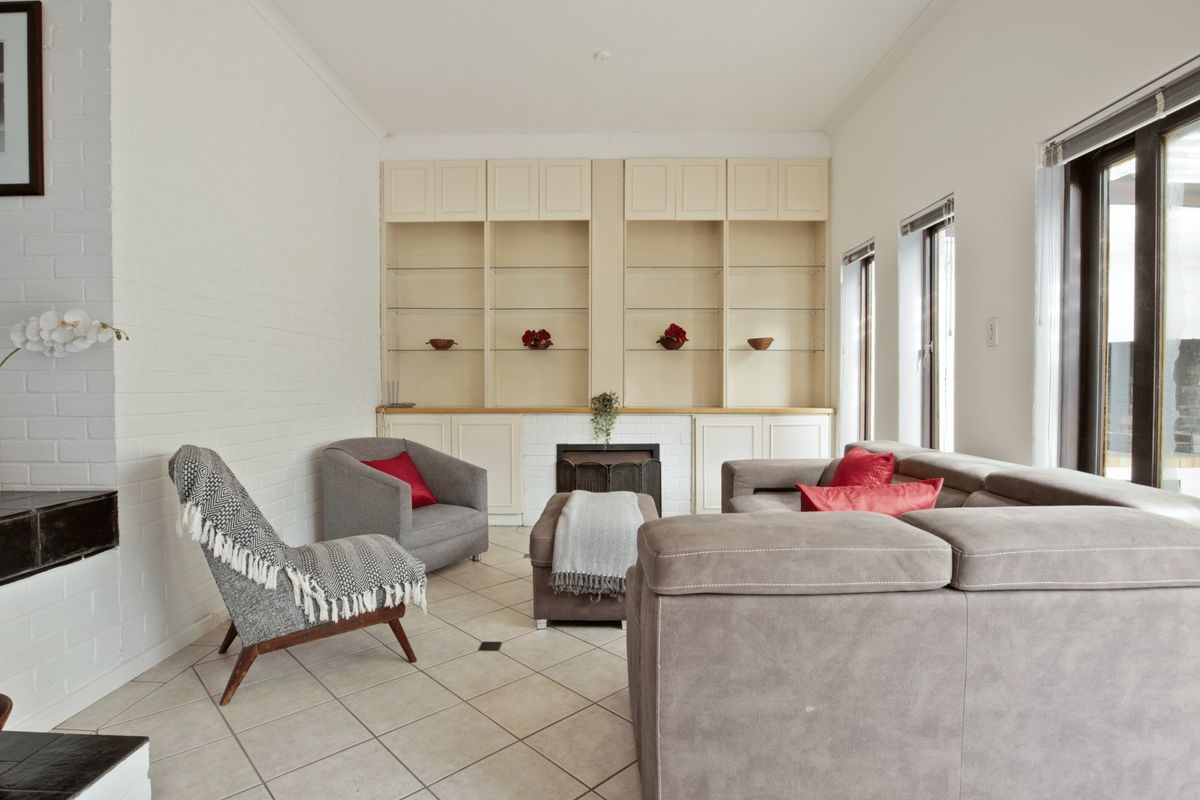 A bright living room featuring built-in cabinetry, a fireplace, and tiled flooring, offering a comfortable and functional space.