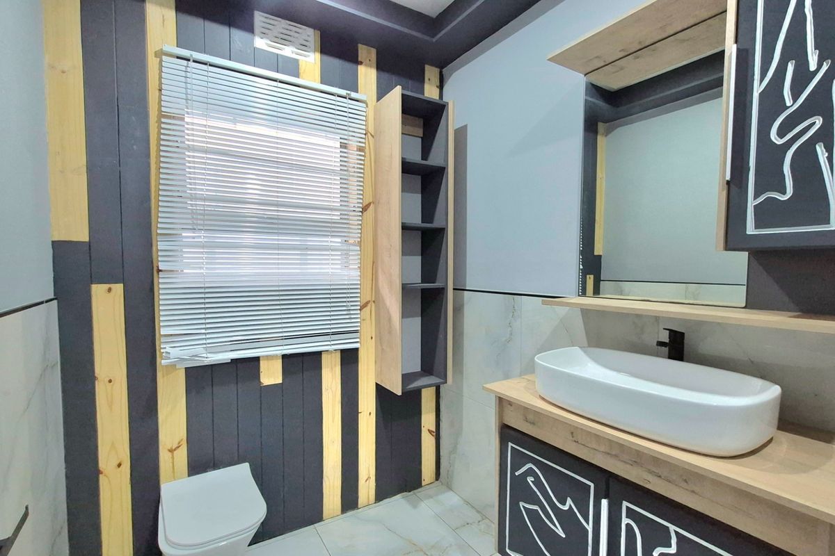 Modern bathroom featuring a vessel sink vanity, built-in shelving, and contemporary wall paneling with a neutral color palette.