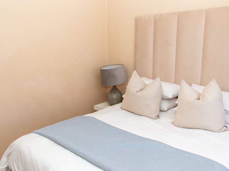 A well-maintained bedroom featuring a neutral color palette and a clean, modern aesthetic.