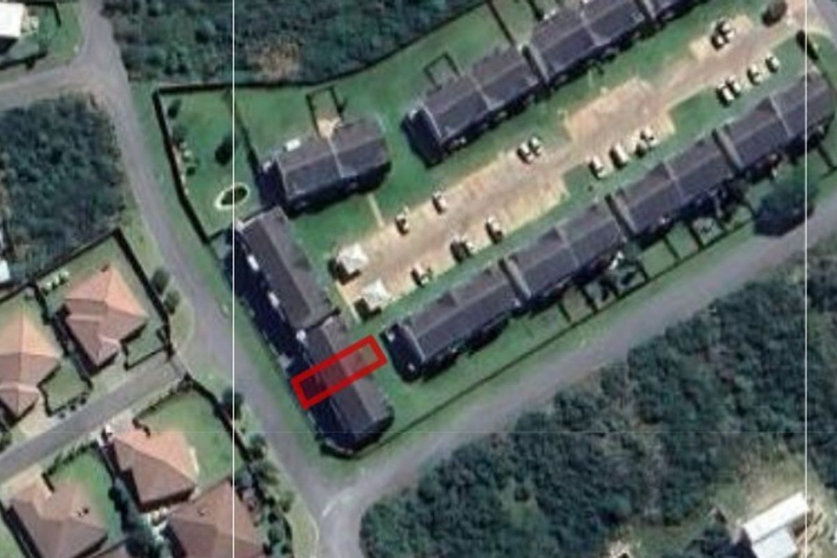 Aerial view of the apartment complex showing the building layout, parking area, and surrounding neighborhood context.