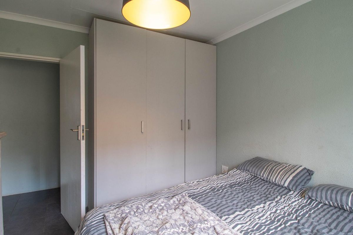 A bedroom featuring built-in cupboards and a neutral color palette, providing functional storage space.