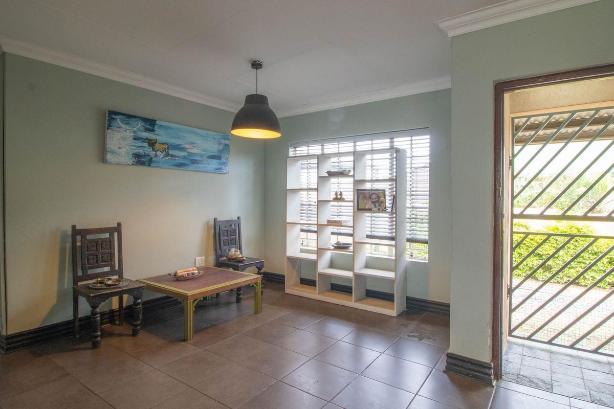 A bright living area featuring tiled flooring, crown molding, and a security gate at the entrance, providing a functional and well-lit space.