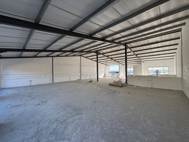 Spacious industrial open-plan area featuring exposed steel structural framing, insulated roofing, and concrete flooring, suitable for warehouse or workshop use.