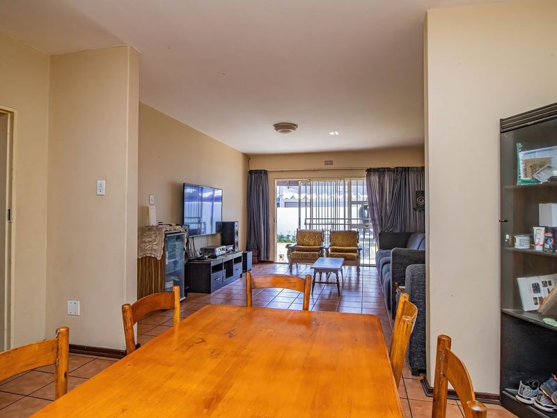 Open-plan living and dining area featuring tiled flooring and a sliding glass door providing access to the outdoor space.