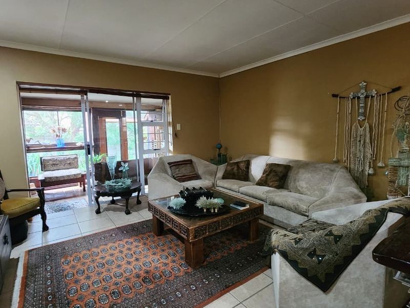 A living room featuring tiled flooring and large sliding glass doors that provide access to an adjoining patio area.