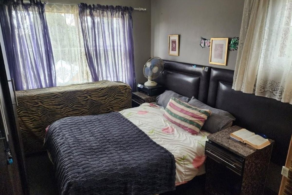 A standard bedroom featuring neutral wall finishes and window treatments, providing a functional sleeping space within the townhouse.