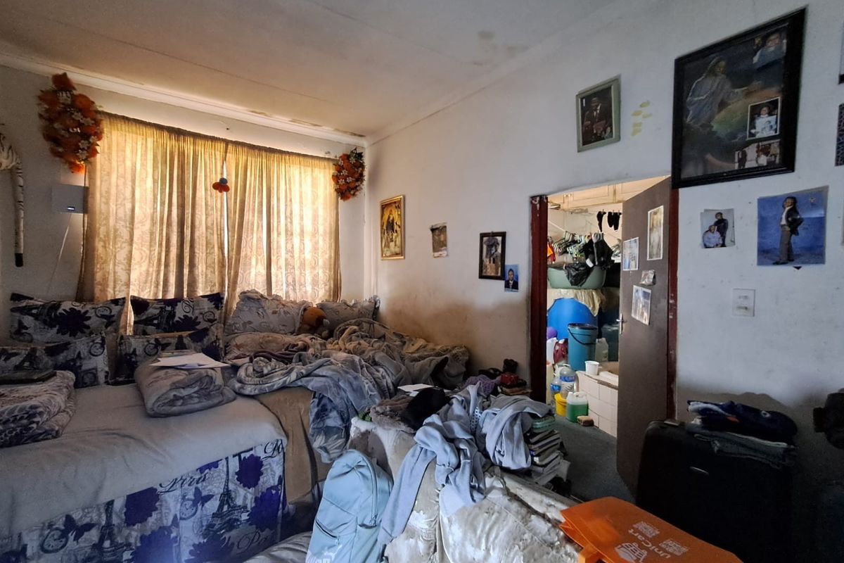 A bedroom featuring a large window with curtains and a doorway leading to an adjacent utility area.