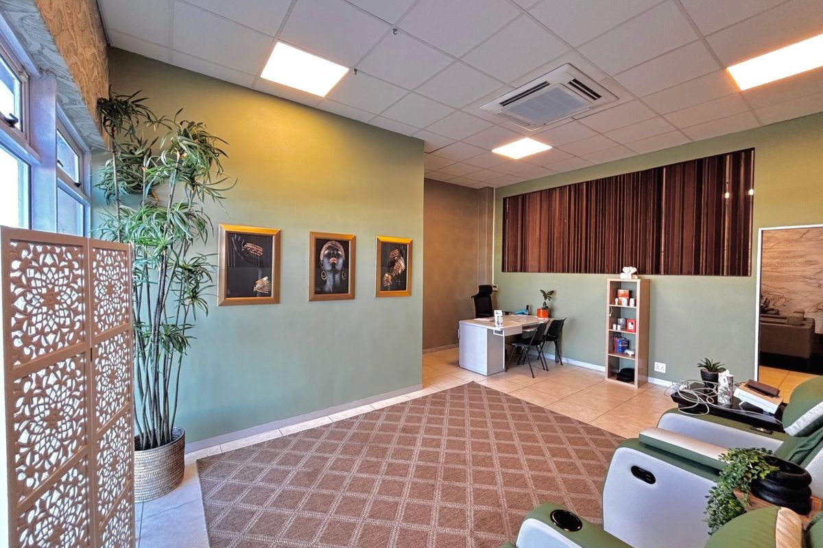 A professional office space featuring a suspended acoustic ceiling, recessed lighting, integrated air conditioning unit, and tiled flooring.