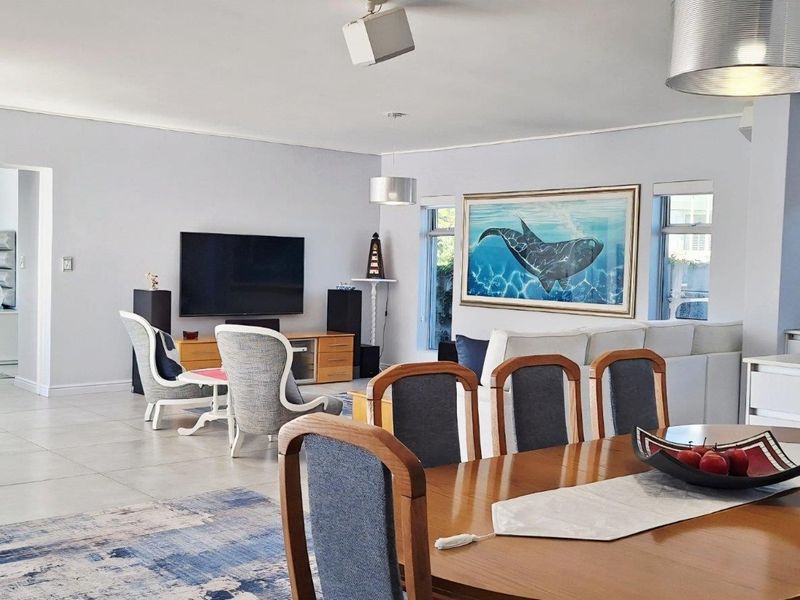 Spacious open-plan living and dining area featuring tiled flooring, recessed lighting, and a seamless flow between the lounge, dining space, and kitchen.