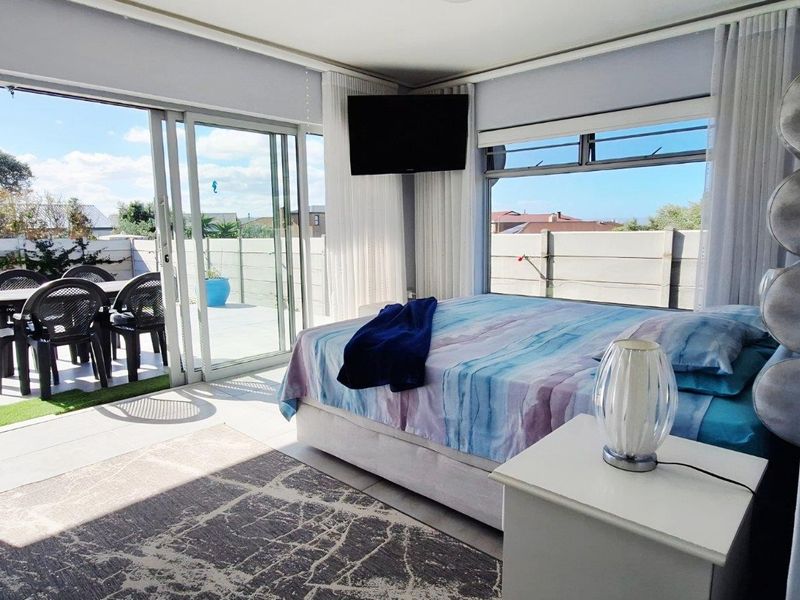 Spacious bedroom featuring large sliding glass doors that open directly onto a private patio area, providing seamless indoor-outdoor flow and abundant natural light.