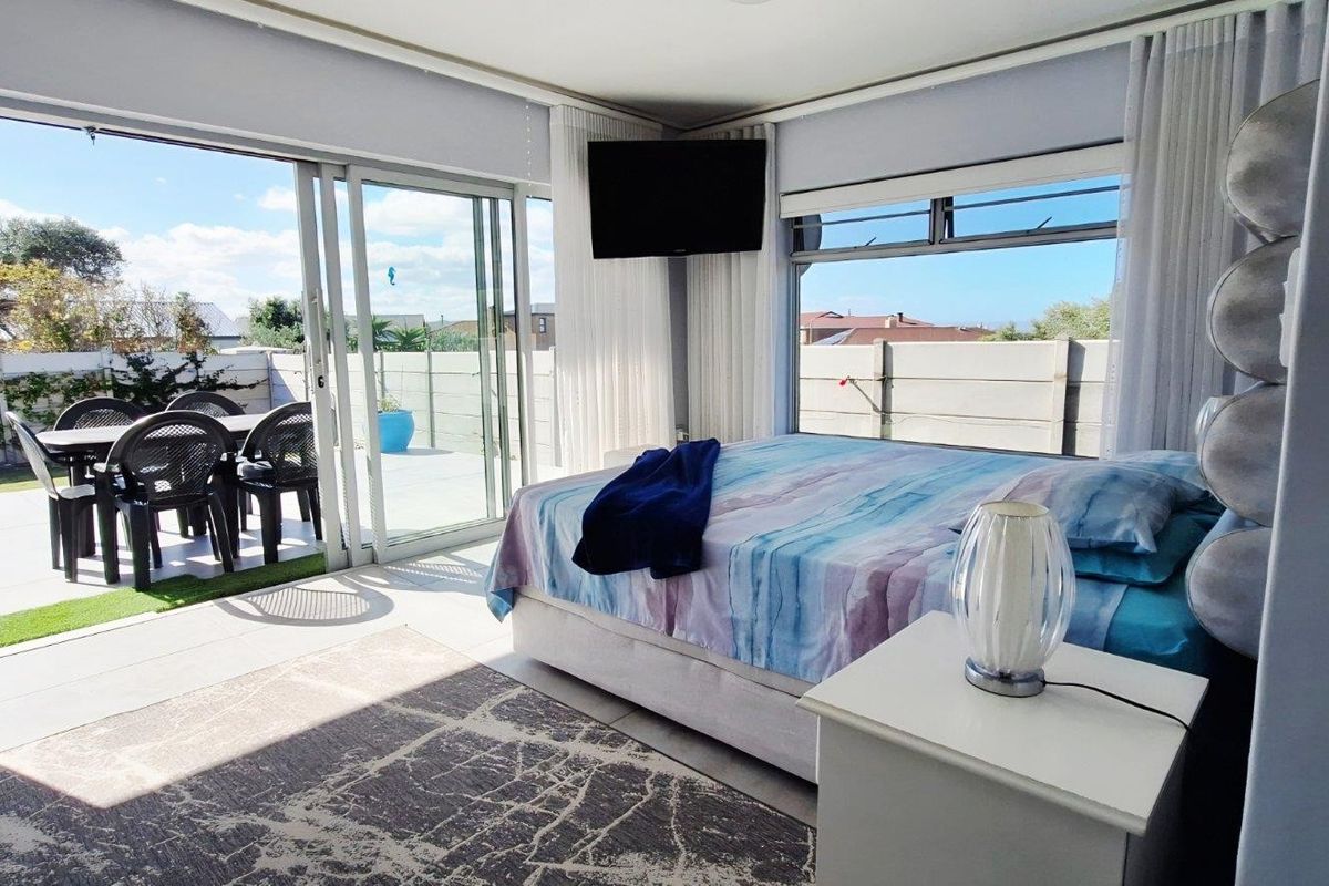 Spacious bedroom featuring large sliding glass doors that open directly onto a private patio area, providing seamless indoor-outdoor flow and abundant natural light.