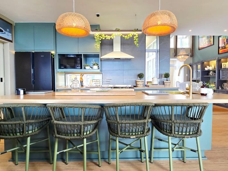 Modern open-plan kitchen featuring a large central island with breakfast bar seating, sleek cabinetry, and high-quality finishes throughout the space.