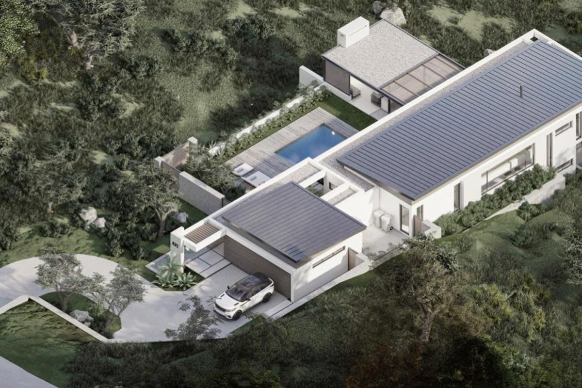 Aerial view of a modern residential property featuring a swimming pool, landscaped garden, and integrated garage, set within a natural hillside environment.