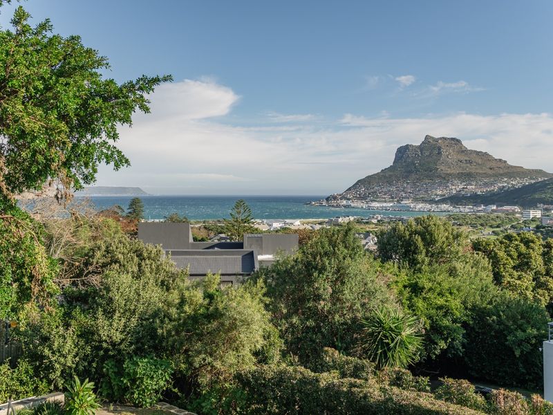 A scenic elevated view overlooking the coastal landscape, bay, and mountain range, showcasing the property's prime location and natural surroundings.