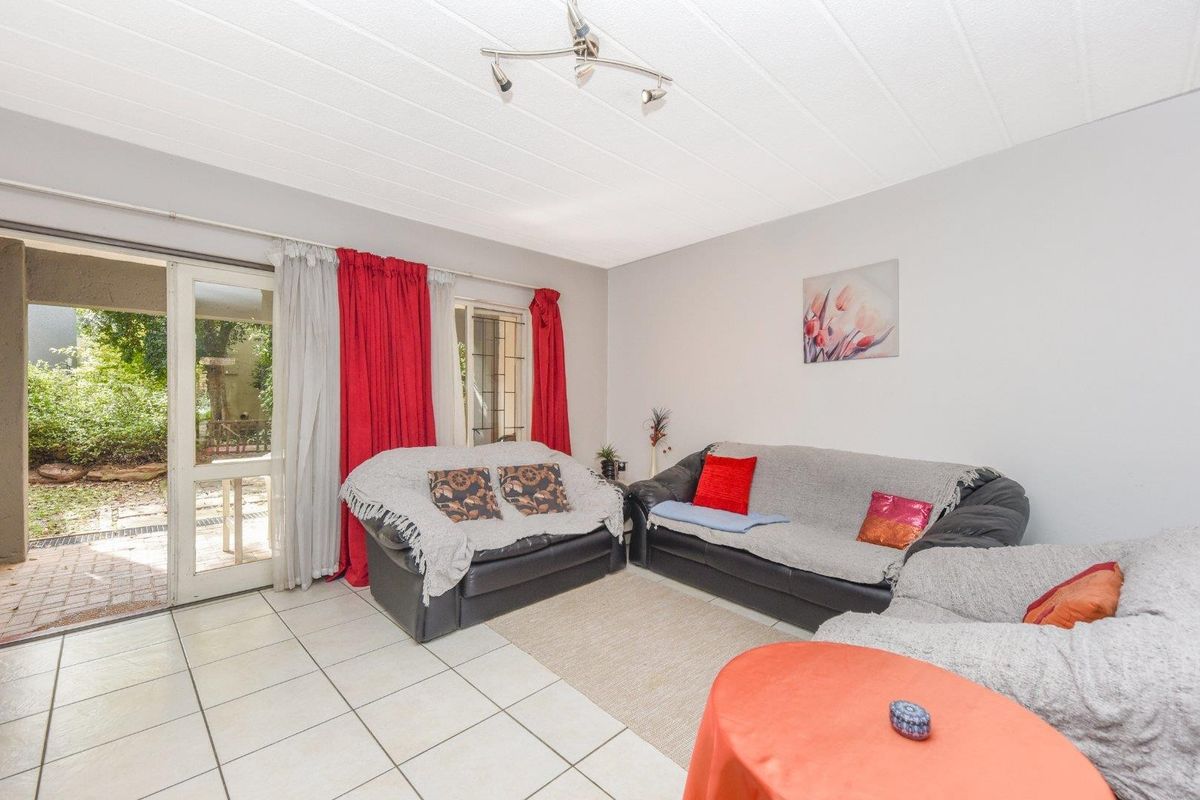 A living room featuring tiled flooring and a sliding glass door providing direct access to an outdoor patio area.
