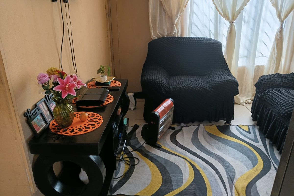 A cozy living room area featuring tiled flooring and a wall-mounted television setup.