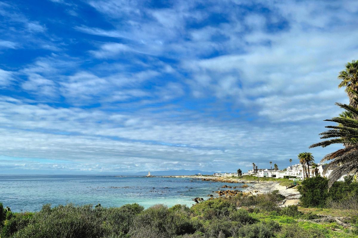 A scenic coastal view overlooking the ocean, rocky shoreline, and nearby residential properties, showcasing the natural beauty and prime location of the land.