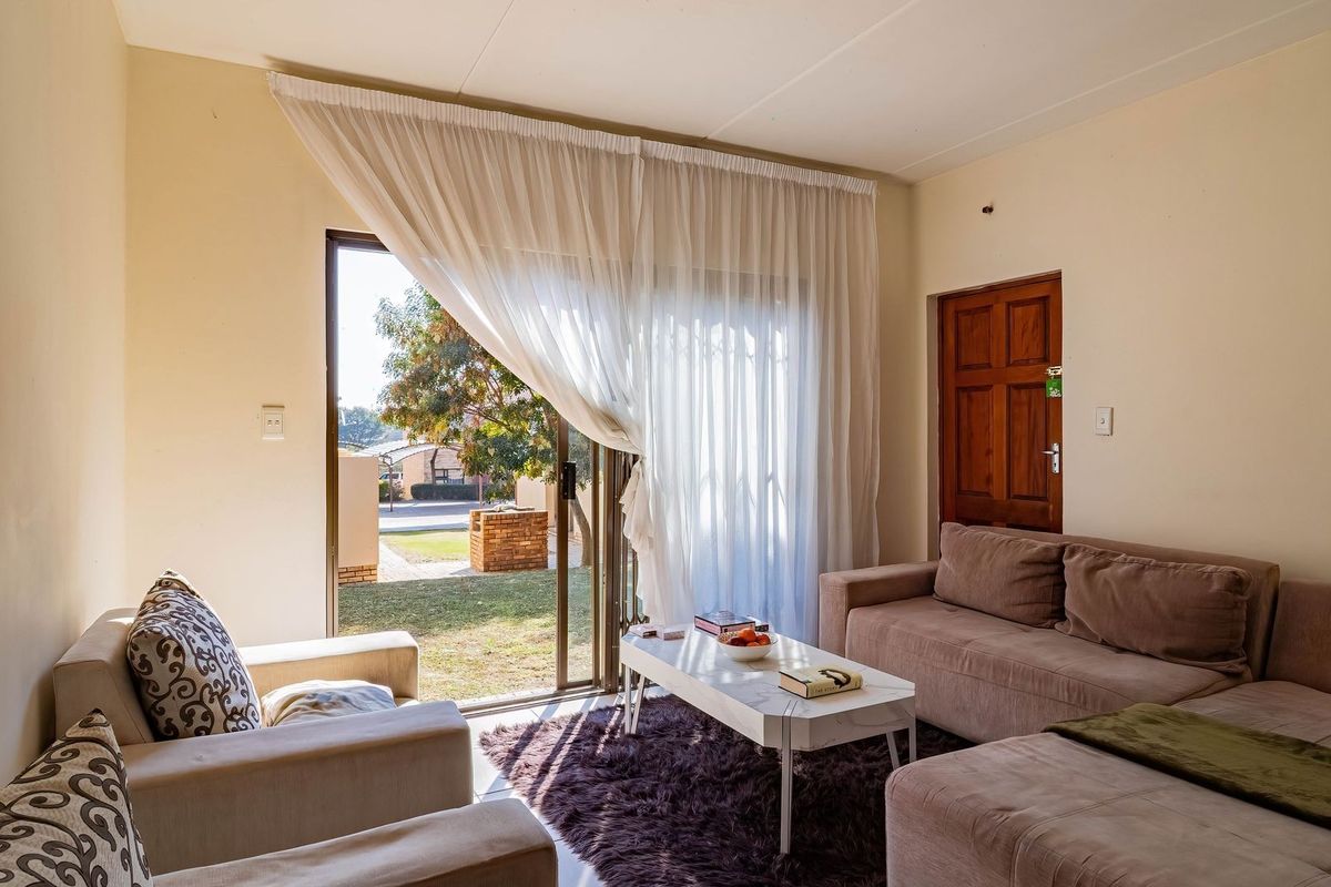A comfortable living room featuring tiled flooring and a large sliding glass door that provides direct access to the outdoor area.