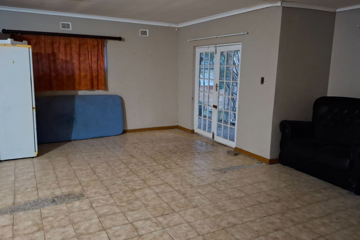 Spacious living area featuring tiled flooring and double glass doors providing direct access to the outdoor area.