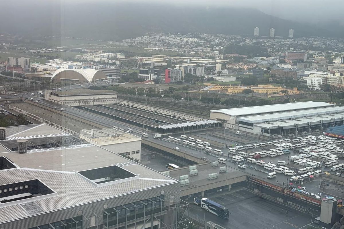 Elevated aerial view overlooking the city infrastructure, including the central transport hub, railway lines, and surrounding urban landscape.