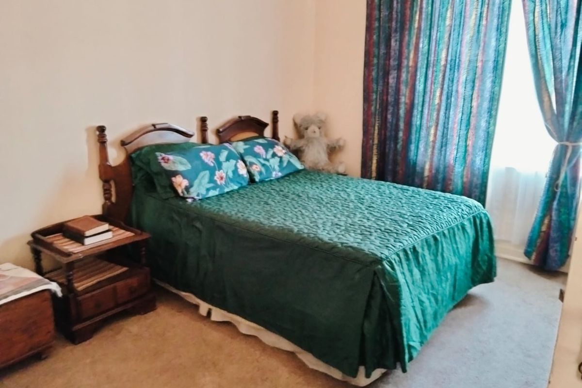 A bedroom featuring neutral wall finishes and carpeted flooring, providing a functional space for rest.