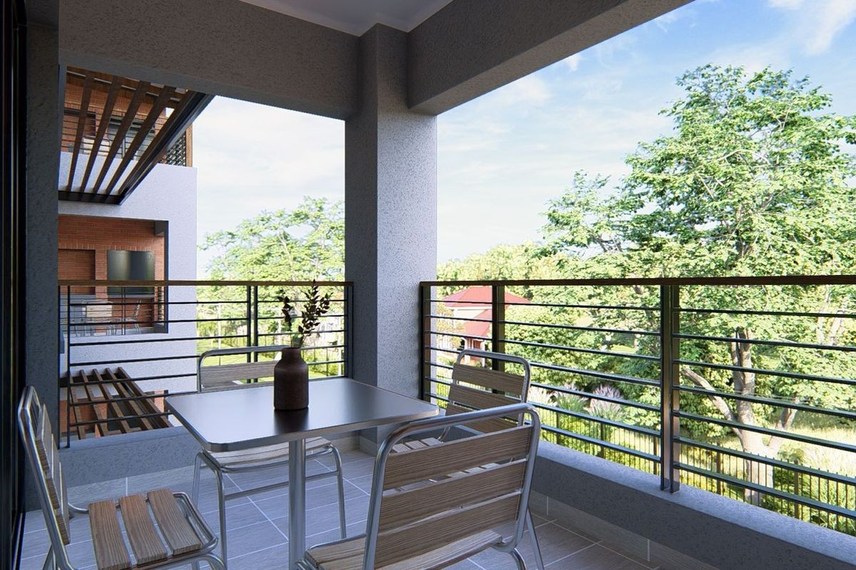 A modern covered balcony featuring tiled flooring and a sleek metal railing, offering pleasant views of the surrounding greenery.