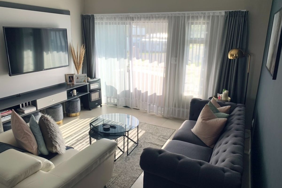 A well-maintained living room featuring large sliding glass doors that provide ample natural light and access to the outdoor area.