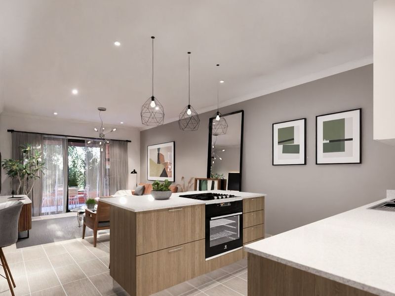 Modern open-plan kitchen and living area featuring a central island with built-in oven and cooktop, leading to a bright patio space.