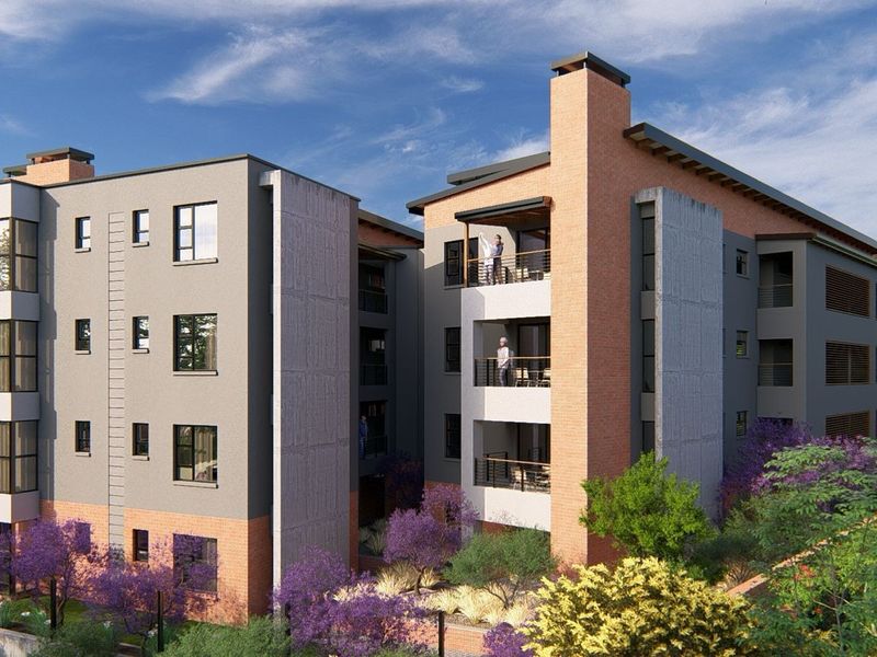 A modern multi-story apartment complex featuring a combination of brick and concrete facade finishes with private balconies and landscaped surroundings.
