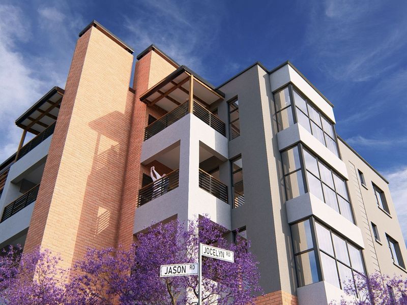 A modern apartment building exterior featuring brick and rendered facades, large windows, and private balconies, situated at the corner of Jason and Jocelyn Road.