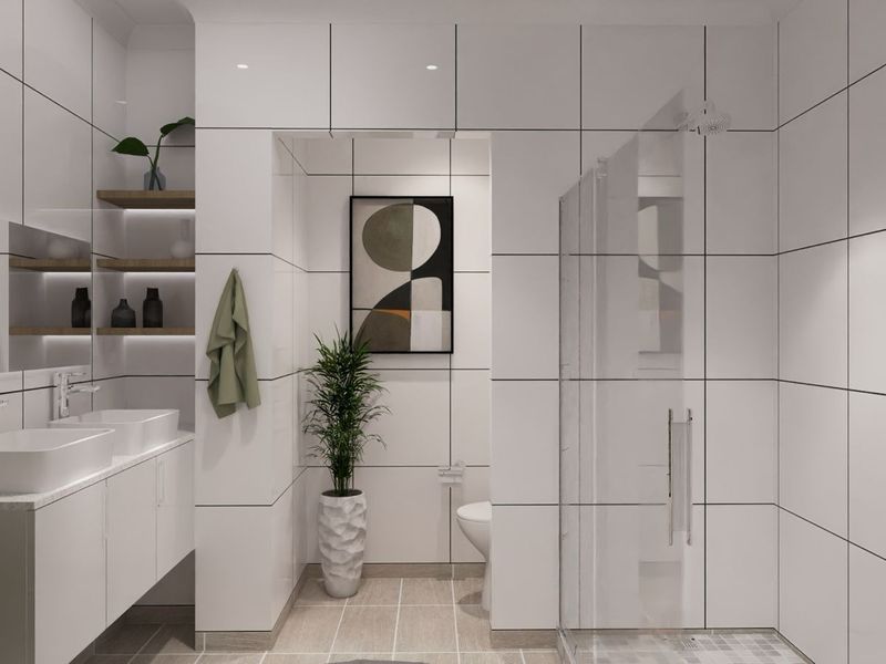 Modern bathroom featuring a double vanity with integrated sinks, a glass-enclosed walk-in shower, and contemporary white wall tiling with dark grout lines.