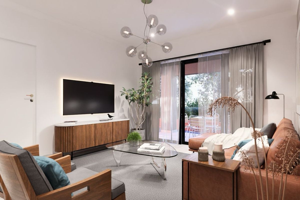 A modern, well-lit living room featuring a sleek media wall, contemporary light fixture, and large sliding glass doors leading to an outdoor patio area.