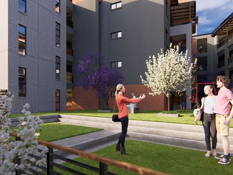 A modern apartment complex courtyard featuring landscaped tiered lawns, paved walkways, and integrated recreational play areas for residents.
