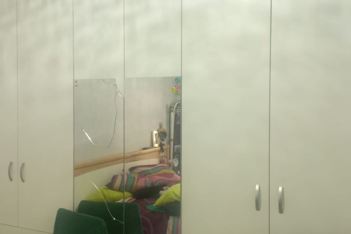 Bedroom featuring a large wall-to-wall built-in wardrobe with integrated mirror panels.