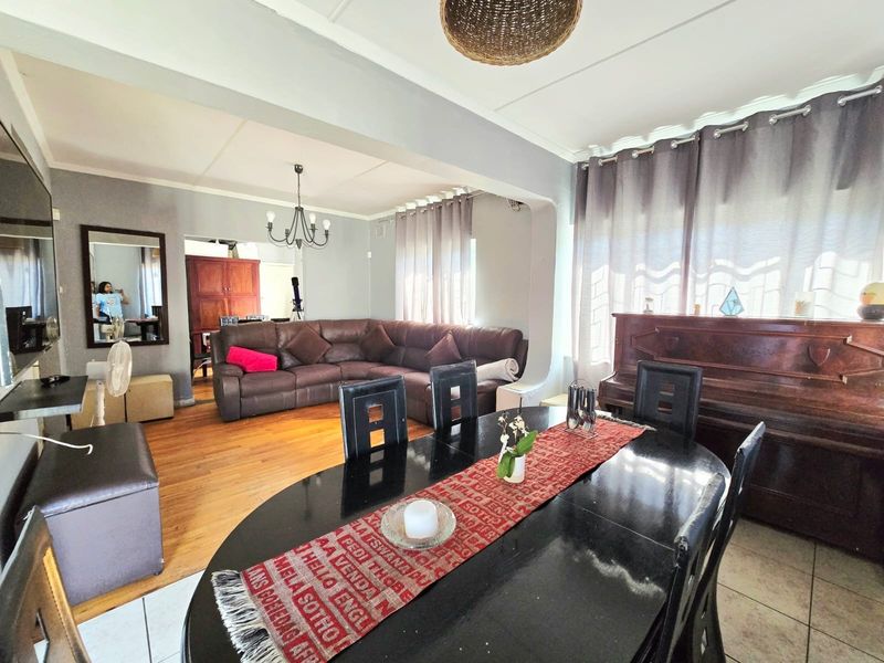 Open plan living and dining area featuring hardwood flooring, neutral wall tones, and a spacious layout suitable for family gatherings.