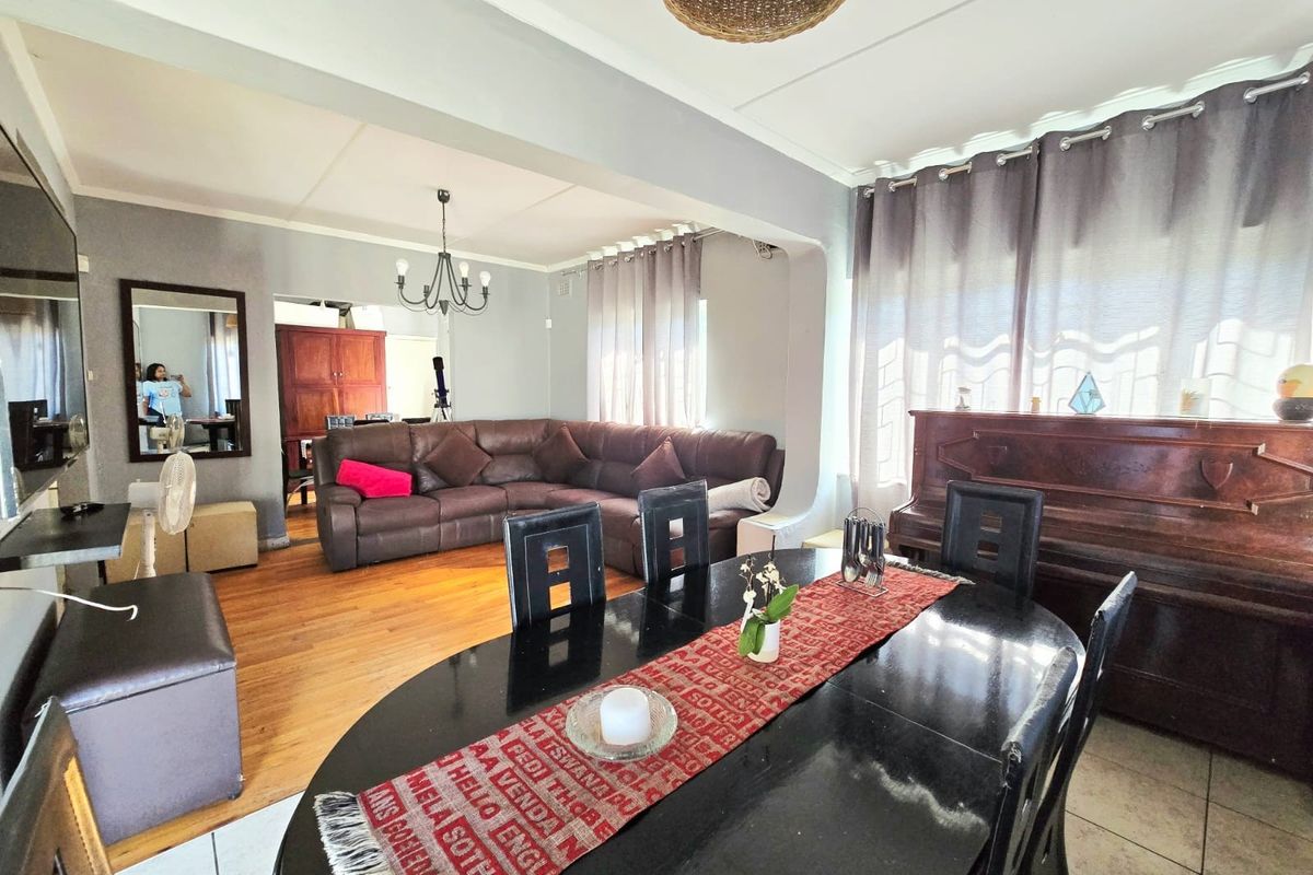 Open plan living and dining area featuring hardwood flooring, neutral wall tones, and a spacious layout suitable for family gatherings.