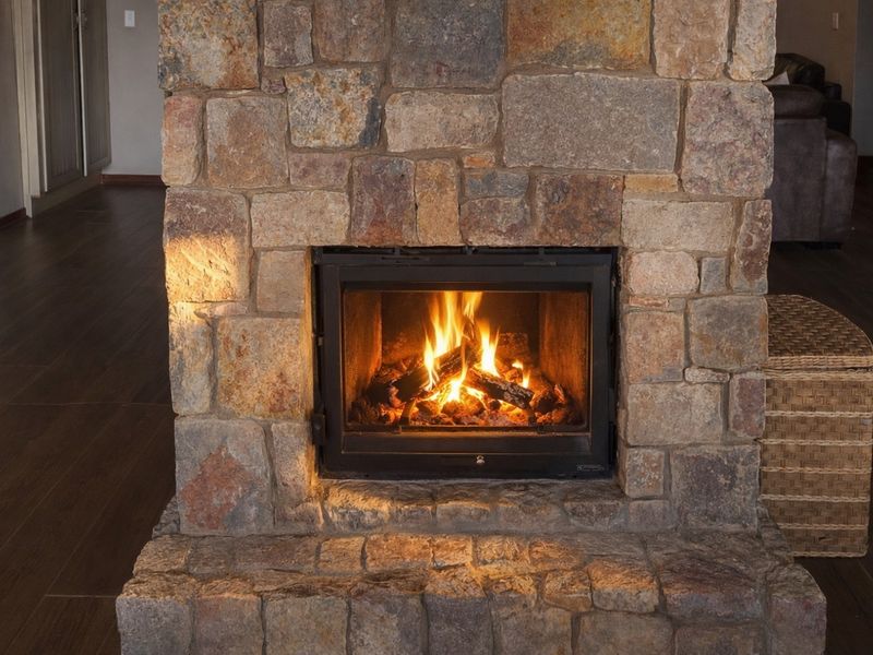 A feature stone fireplace with a built-in wood-burning insert, creating a warm focal point in the living area.