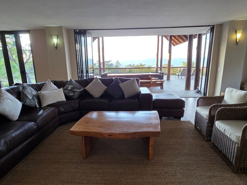 Spacious open-plan living area featuring large folding glass doors that open onto a covered patio with scenic views.