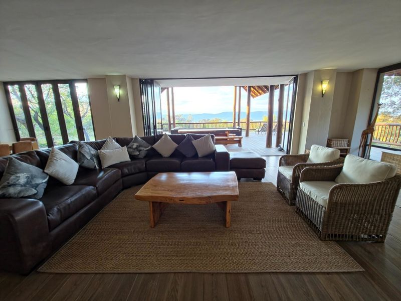 Spacious open-plan living area featuring large folding glass doors that open onto a covered patio with scenic mountain views.