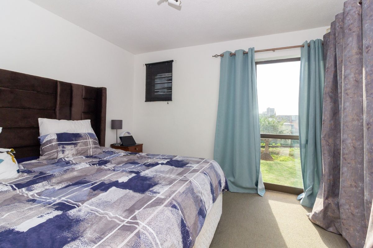 A bedroom featuring carpeted flooring and a large sliding glass door providing natural light and access to the exterior.